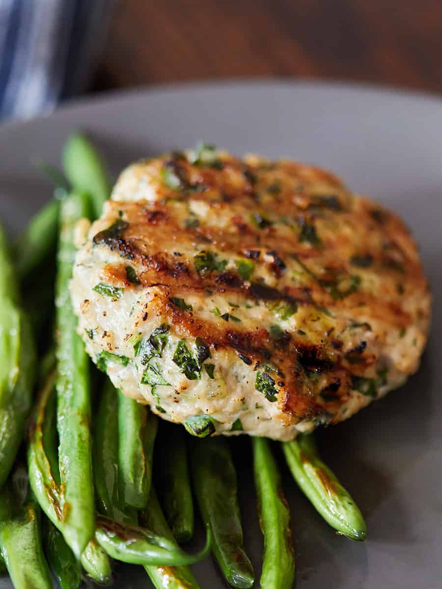 Thai Chicken Burger served on gray plate with side of asparagus