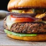 Pinterest graphic of a black bean burger on a wooden serving board.