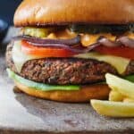 Pinterest graphic of a black bean burger with some fries in front.