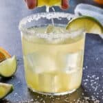 Pinterest graphic of a lime being squeezed into a glass of margarita.