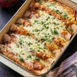 Pinterest graphic of vegetarian enchiladas in a casserole dish beside onions and a linen.
