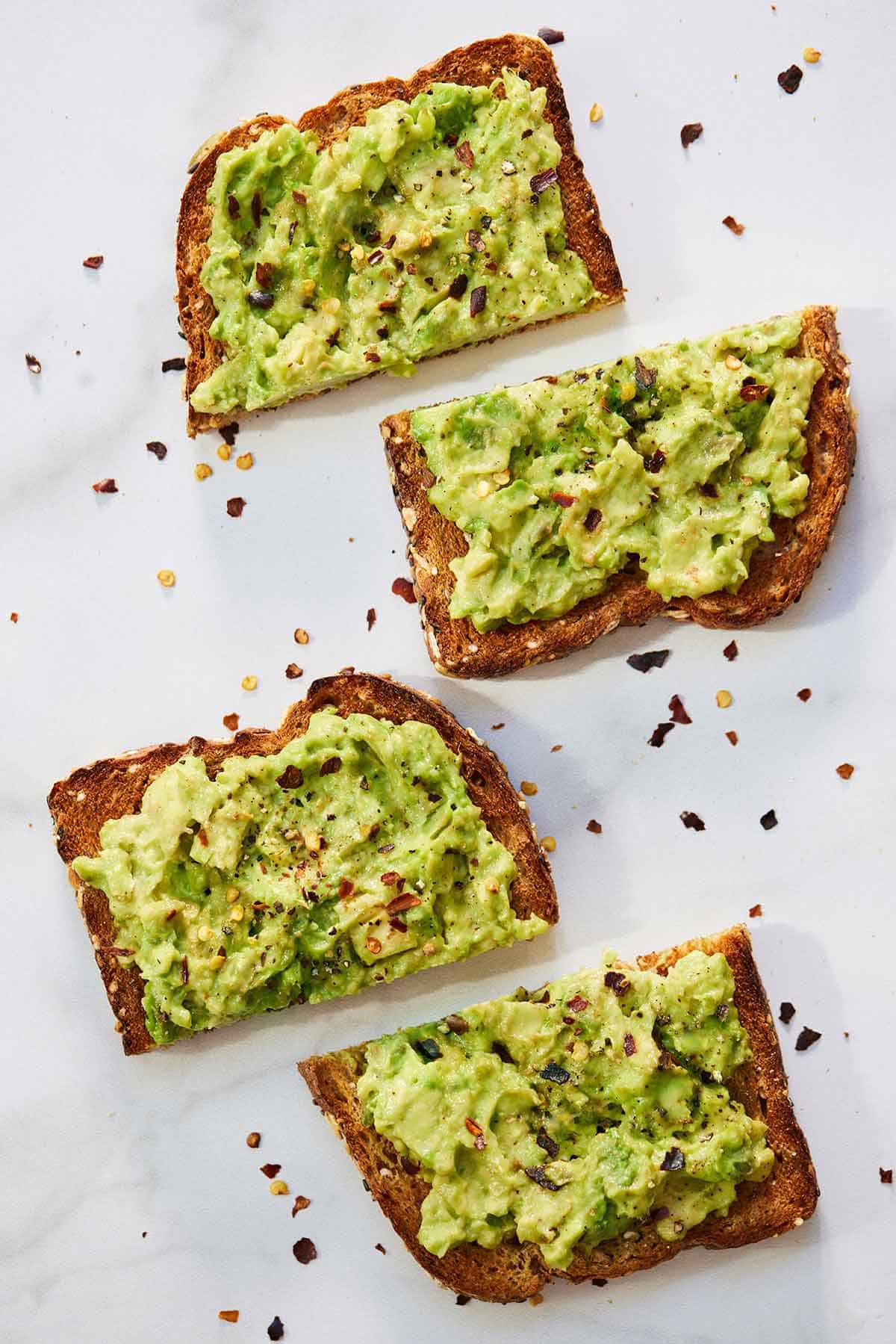Two slices of avocado toast, each cut in half.