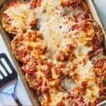 Pinterest graphic of an overhead view of a casserole dish of eggplant parm with golden cheese on top.
