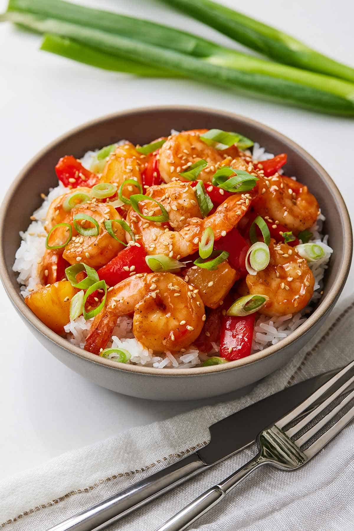 A bowl of sweet and sour shrimp over rice.