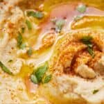 Pinterest graphic of a close up image of hummus with paprika and olive oil.