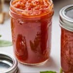 Pinterest graphic of two jars, with one in focus, filled with marinara sauce.