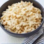 Pinterest graphic of a black bowl of vegan mac and cheese.