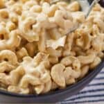 Pinterest graphic of a spoonful of creamy vegan macaroni and cheese.