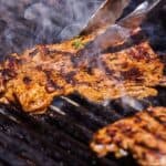 Pinterest graphic of two pieces of carne asada being grilled.