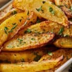 Pinterest graphic of crispy potato wedges made in the air fryer with fresh herbs on top.
