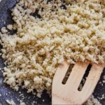 Pinterest graphic of a pan of cauliflower rice with a wooden spatula inside.