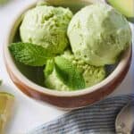 Pinterest graphic of a bowl of avocado ice cream with ingredients scattered around it and a linen napkin.
