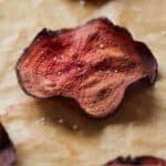 Pinterest graphic of a close up of a beet chip with sea salt sprinkled on top.