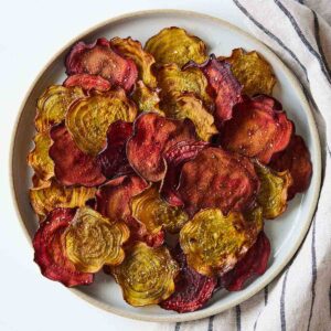 Overhead view of a plate with different colored beet chips.