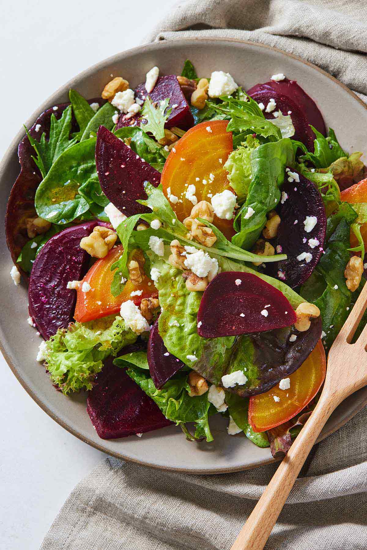 Overhead view of a plate of beet salad with a fork in the plate.