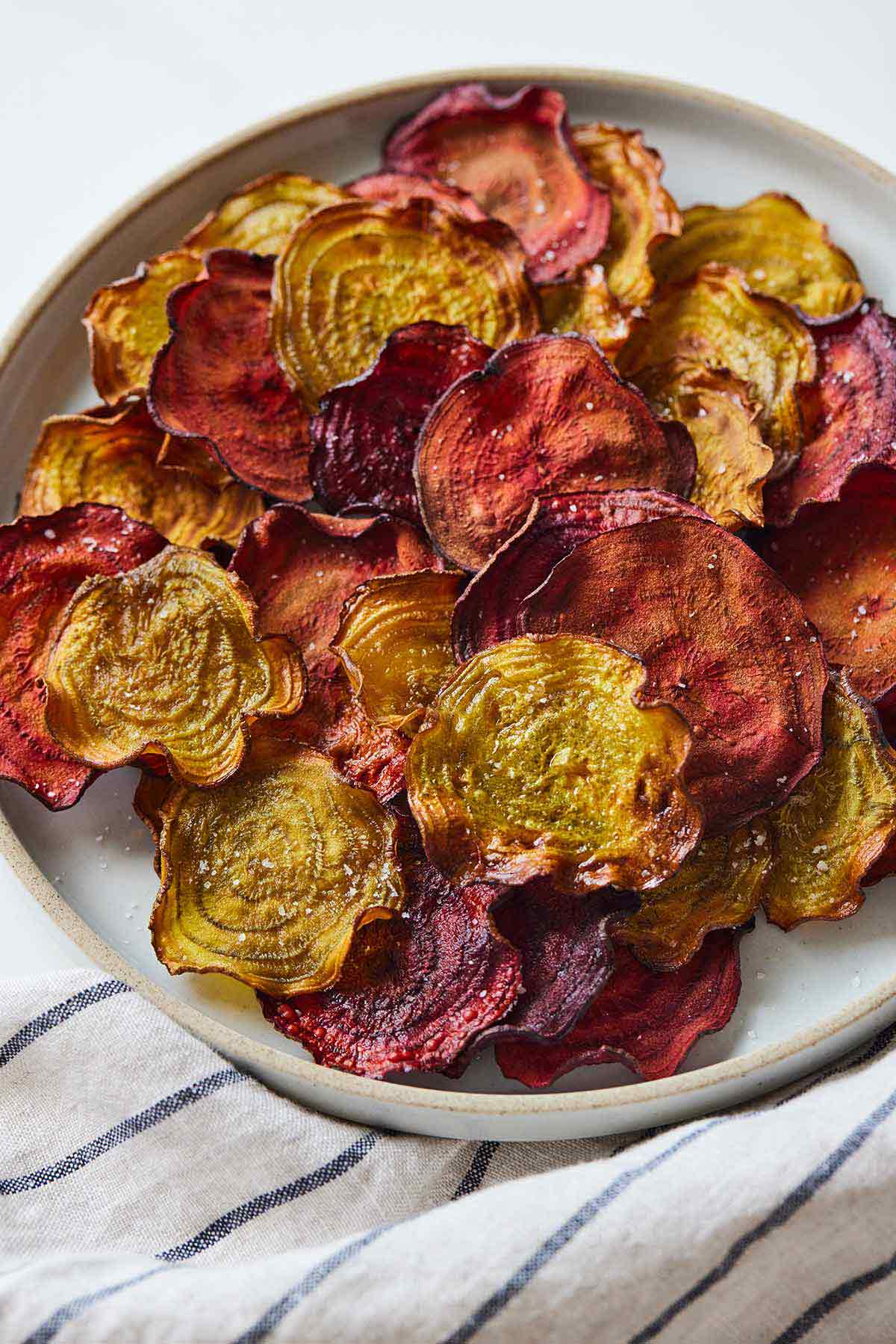 Overhead view of a plate of multi-colored beet chips.