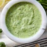 Pinterest graphic showing an overhead view of a small bowl of green goddess dressing.