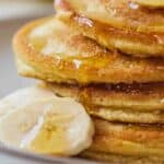 Pinterest graphic of a close up view of a stack of paleo pancakes and sliced bananas.