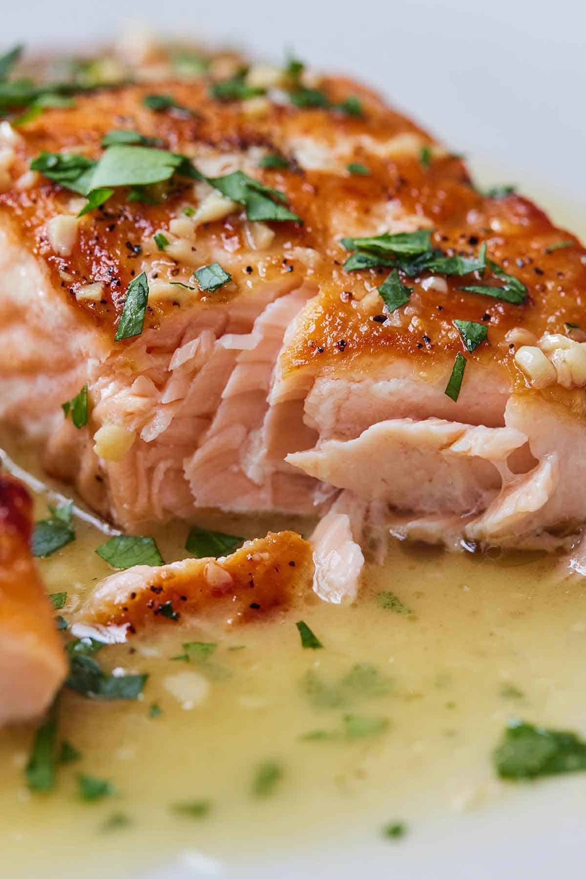 An interior view of a pan seared salmon fillet in a butter sauce.
