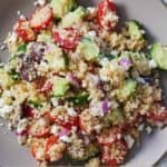 Pinterest graphic of an overhead view of a plate of Greek quinoa salad.