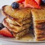 Pinterest graphic of a stack of oatmeal banana pancakes, cut open, with fruit and syrup.