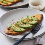 Pinterest graphic of a plates of sweet potato toasts with avocado slices on top and everything but the bagel seasoning.