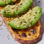Pinterest graphic of a close up image of sweet potato toast topped with avocado slices.