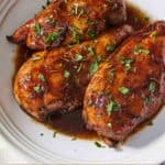 Pinterest graphic of a plate with three balsamic chicken breasts.