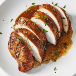 A plate of a balsamic chicken breast, sliced.