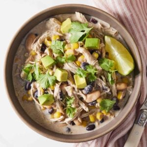 Overhead view of a bowl of instant pot white chicken chili with a wedge of lime in the bowl.