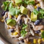 Pinterest graphic of a close up of a bowl of instant pot white chicken chili with diced avocado on top.