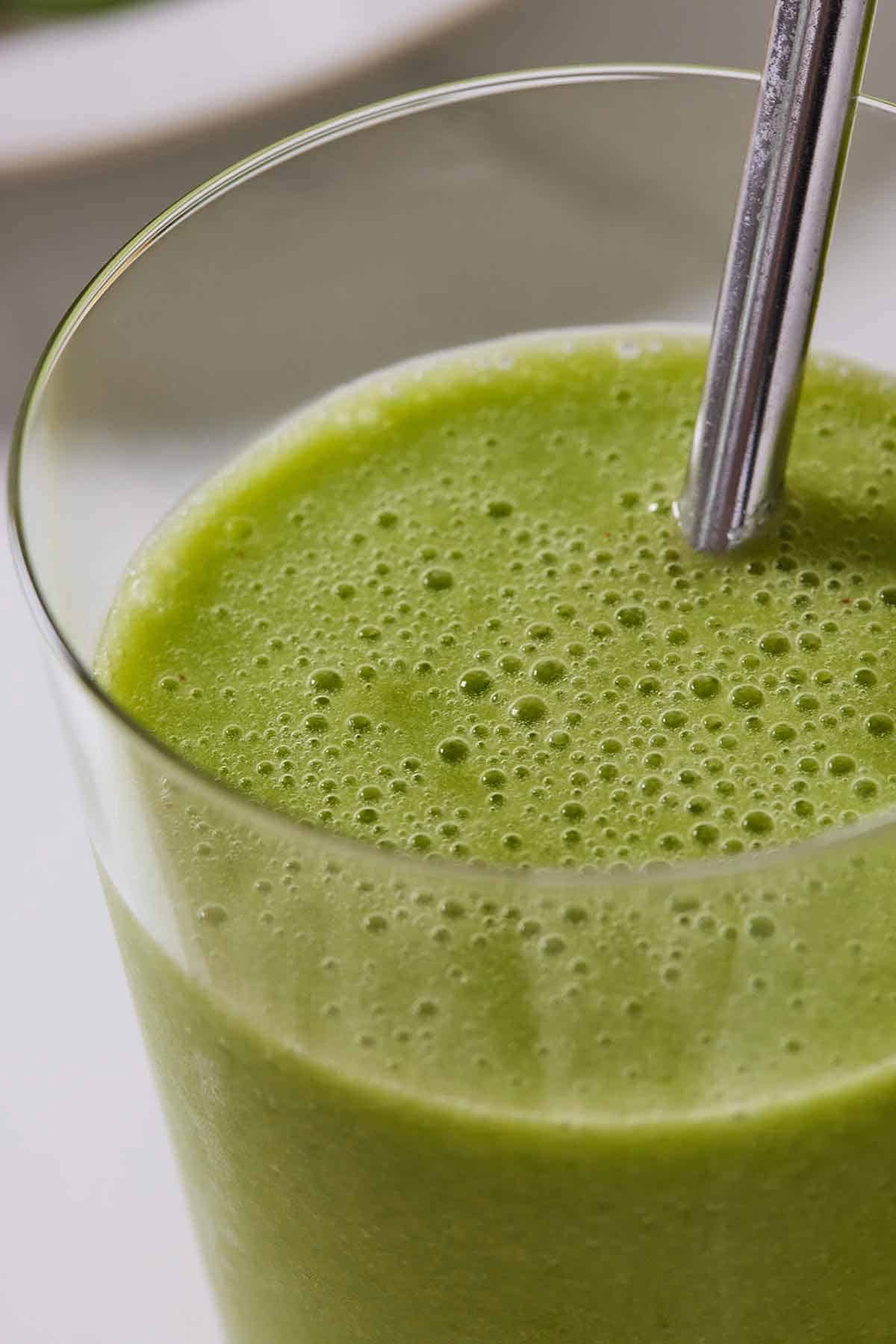 Close up of a green smoothie in a glass.