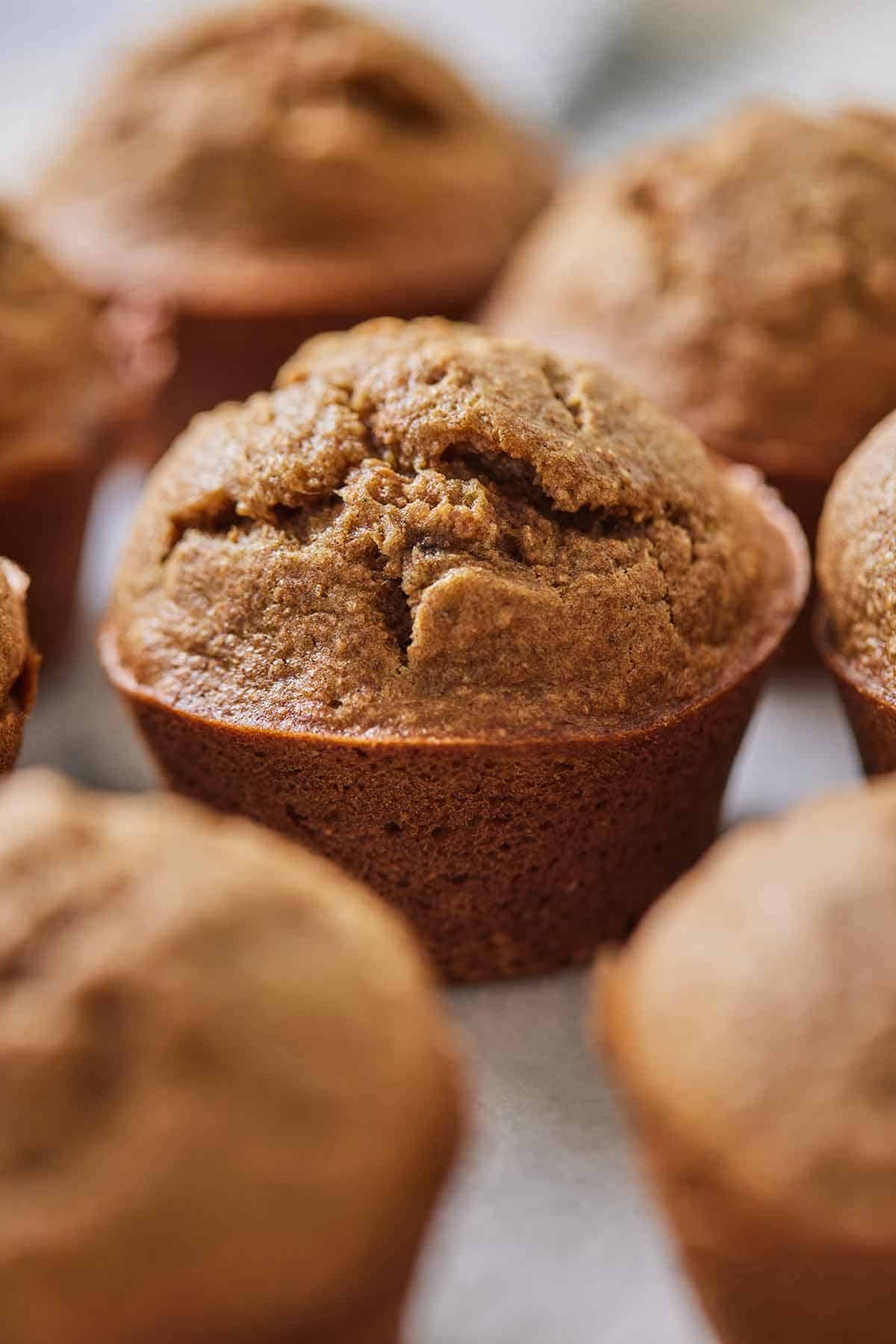 A healthy banana muffin in focus with more surrounding it, out of focus.