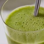 Pinterest graphic of a close up of a green smoothie with a straw.