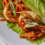 Pinterest graphic of a shrimp lettuce wrap with peanut drizzled on top.