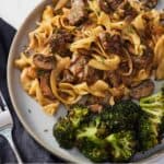 Pinterest graphic of a plate of beef stroganoff with broccoli.