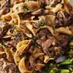 Pinterest graphic of a close up view of beef stroganoff with parsley garnish.