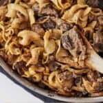 Pinterest graphic of a close up view of a pan of beef stroganoff.