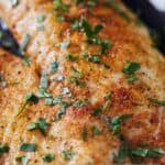 Pinterest graphic of a close up view of an air fryer tilapia with parsley garnish.