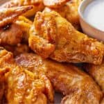 Pinterest graphic of the close up of an air fryer chicken wing on top of a plateful.