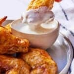 Pinterest graphic of an air fryer chicken wing dipped in sauce.