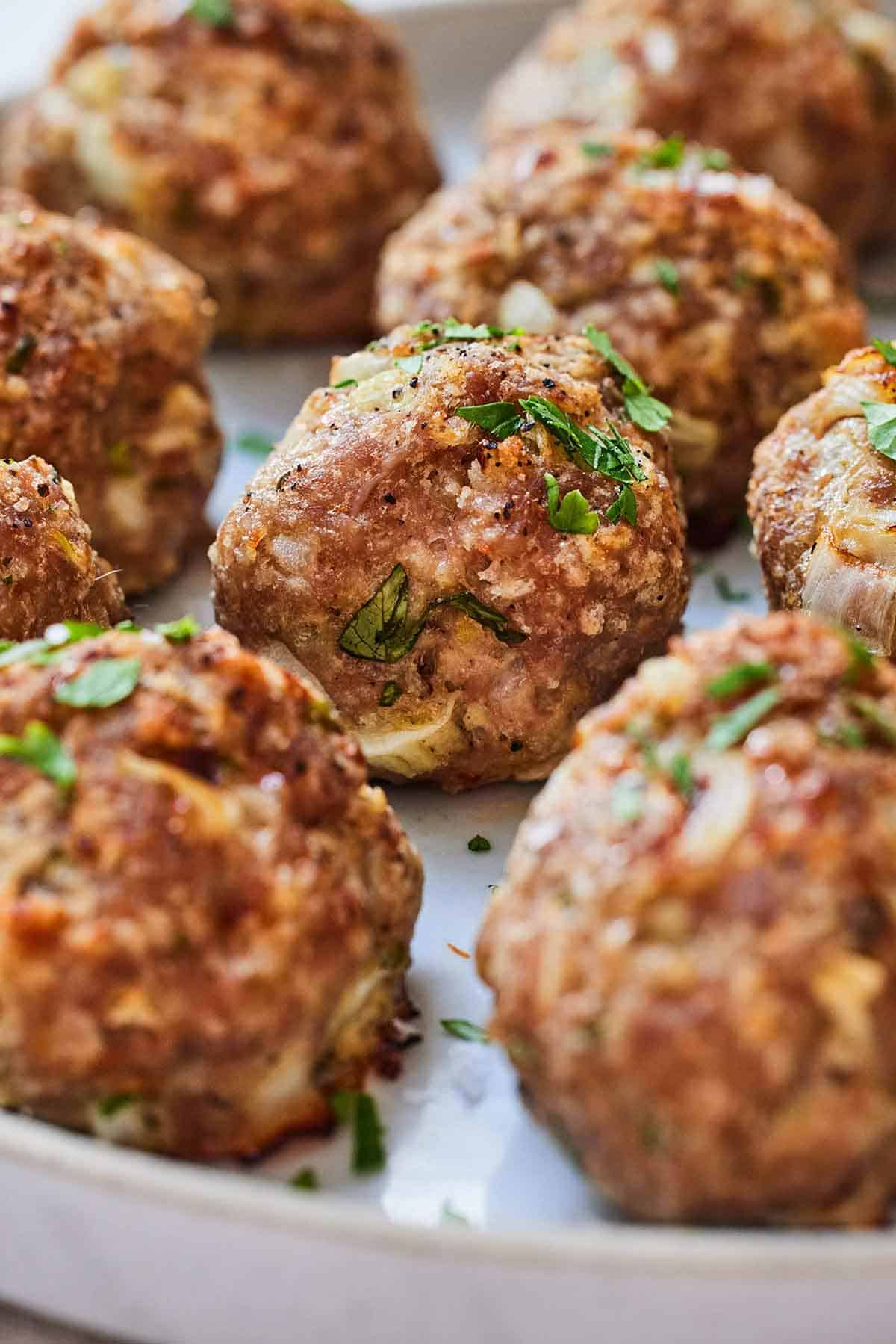 Close up of rows of turkey meatballs on a plate.
