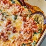 Pinterest graphic of a close up view of eggplant lasagna in a baking dish.