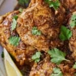 Pinterest graphic of a close up view of Instant Pot lemon garlic chicken with parsley and a lemon wedge.