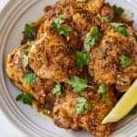 Pinterest graphic of an overhead view of a plate of Instant Pot lemon garlic chicken with parsley on top.
