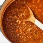 Pinterest graphic of a pot of lentil stew with a wooden spoon.