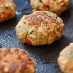 Pinterest graphic of a salmon cake in focus inside a pan.