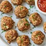 Pinterest graphic of a plate of multiple turkey meatballs with parsley sprinkled on top.
