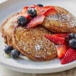 Pinterest graphic of a plate with three whole wheat pancakes and garnishes.