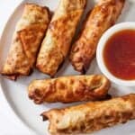 Pinterest graphic of a plate of air fryer egg rolls with a dipping sauce off to the side.